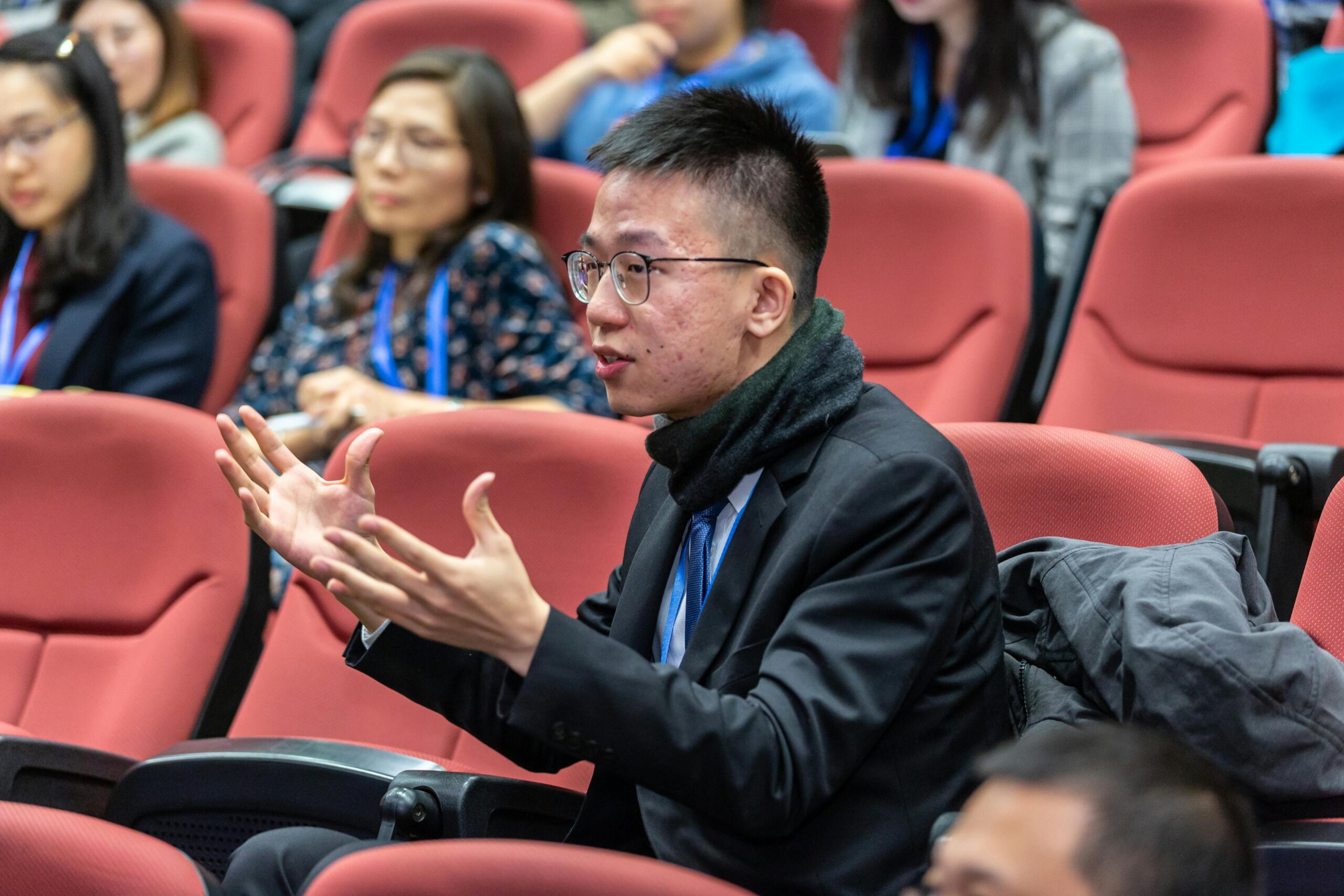 Students actively participating in a university lecture, discussing and engaging.